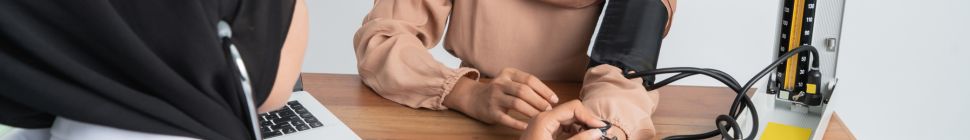 Woman getting a check-up, blood pressure measured