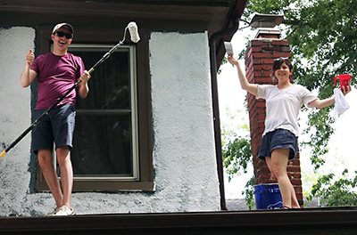 Aubrey and colleague painting a house