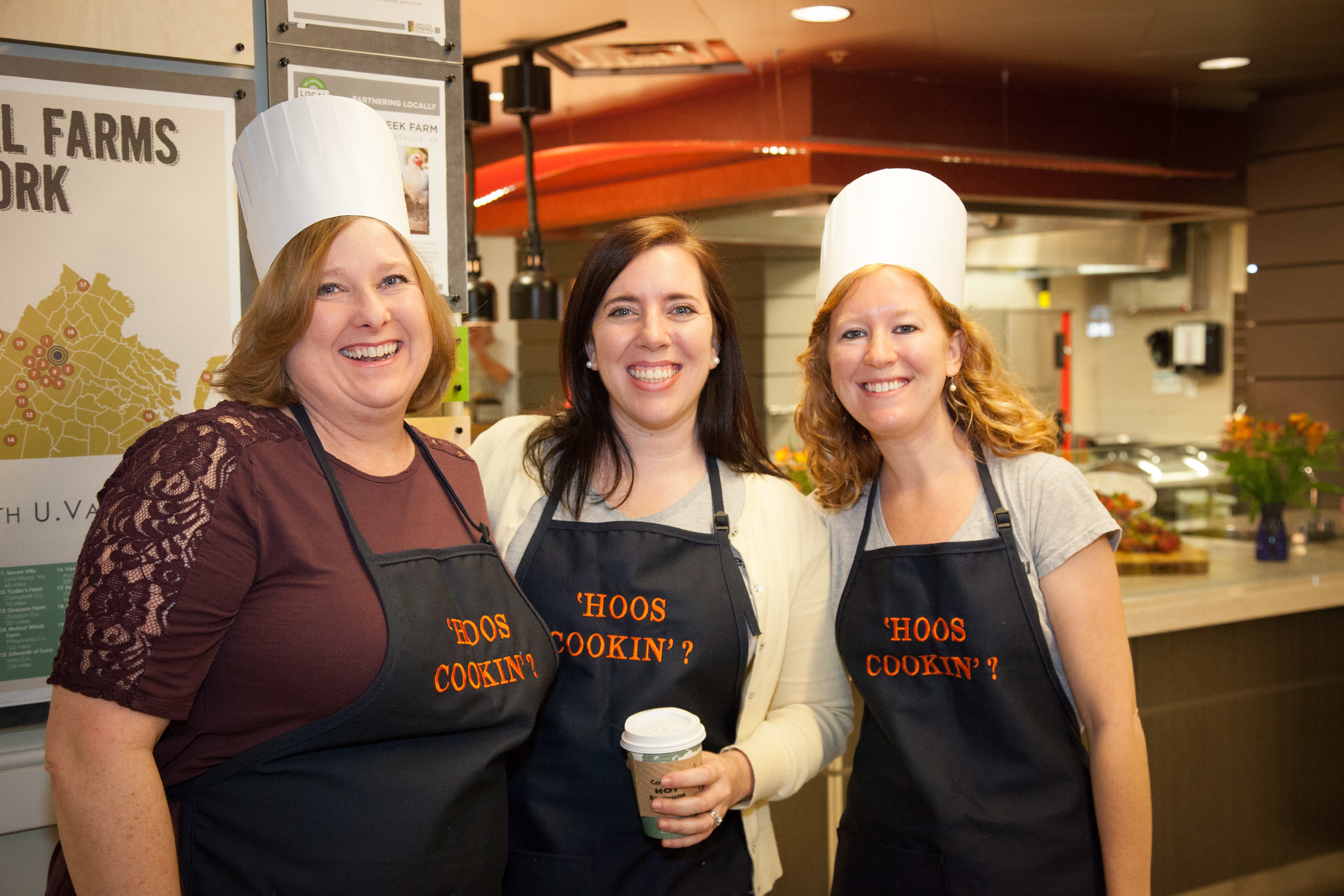 Sarah and Collogues smiling wearing 'Hoos Cooking Aprons 