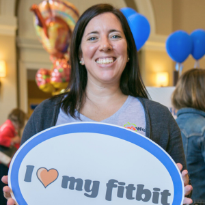 Sarah holding a sign that reads I <3 (love) my Fitbit