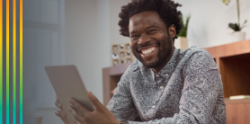 Man smiling holding a tablet.